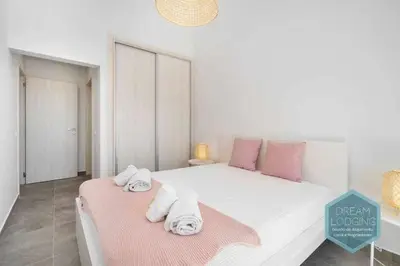 a white bedroom with a bed with towels on it at Casa do Alto - Dream Lodging in Albufeira