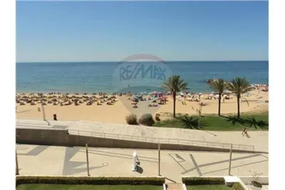 a beach with a large crowd of people on it at Quarteira 1-Bed Sleeps 4 Parking 1 min to Beach in Quarteira