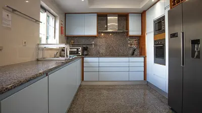 a kitchen with white cabinets and granite counter tops at Villa Mar Ali - JACUZZI - 400m from the beach - BY BEDZY in Albufeira