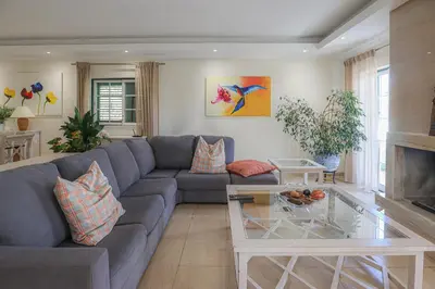 a living room with a blue couch and a table at Villa Mar Ali - JACUZZI - 400m from the beach - BY BEDZY in Albufeira