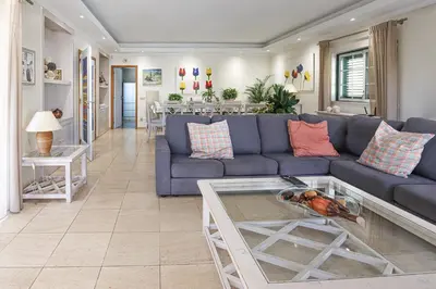 a living room with a blue couch and a table at Villa Mar Ali - JACUZZI - 400m from the beach - BY BEDZY in Albufeira