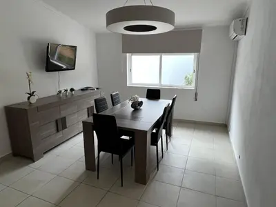 a dining room with a table and chairs and a television at Plage in Albufeira