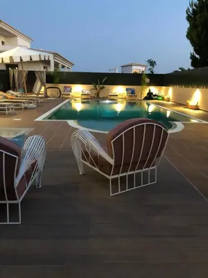 two chairs sitting next to a swimming pool at night at Villa Mar Azul in Albufeira