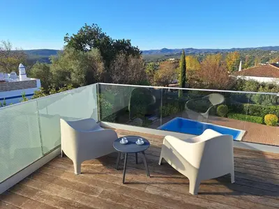 a balcony with two chairs and a swimming pool at Casa Bravo in Querença