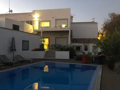 a villa with a swimming pool in front of a house at Casa Bravo in Querença