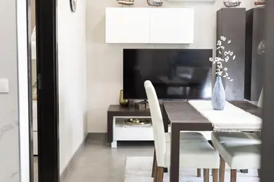 a dining room with a table and chairs and a tv at Marina Luxor - Vilamoura in Quarteira