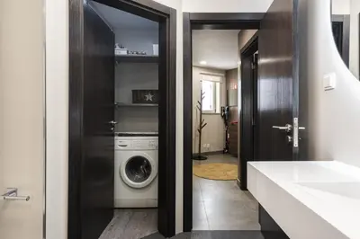 a bathroom with a washer and dryer in a room at Marina Luxor - Vilamoura in Quarteira