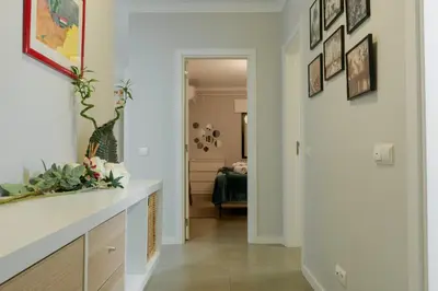 a hallway with white walls and a white counter and a room at Comfort Zone beach apartment in Quarteira