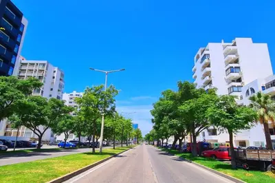 an empty street in a city with tall buildings at Comfort Zone beach apartment in Quarteira