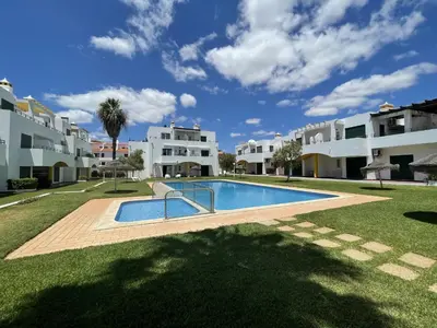 a swimming pool in front of some apartment buildings at Vila Flor - Vilamoura in Vilamoura