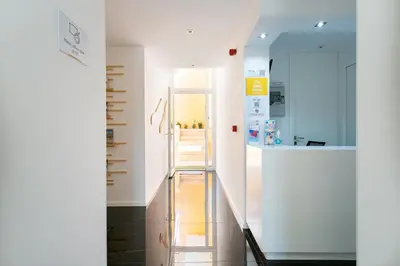 a hallway with white walls and a stair case at Casa Amarela Guesthouse in Albufeira