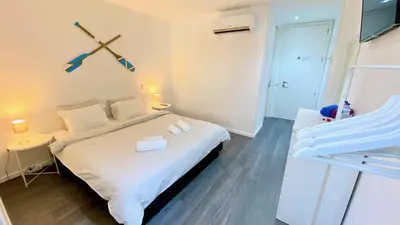 a bedroom with a bed and a clock on the wall at Casa Amarela Guesthouse in Albufeira