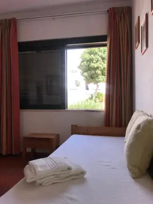 a bedroom with a white bed and a window at Comfortable Appartment at Albufeira in Albufeira