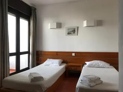 two beds in a room with a window at Comfortable Appartment at Albufeira in Albufeira