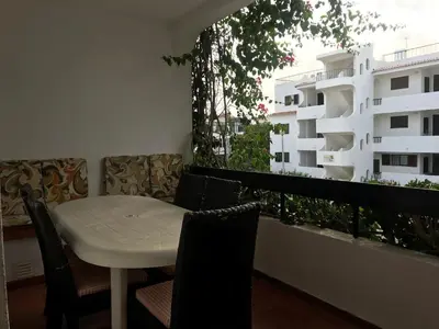 a white table and chairs on a balcony with a building at Comfortable Appartment at Albufeira in Albufeira