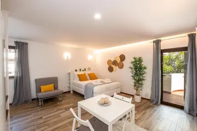 a living room with a large bed and a kitchen at #027 T0 Belavista by Home Holidays in Albufeira
