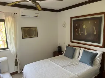 a bedroom with a white bed with blue pillows at Falesia Beach Town house 2 bedroom in Olhos de Água