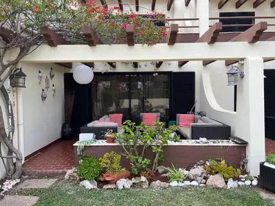 a house with a patio with chairs and flowers at Falesia Beach Town house 2 bedroom in Olhos de Água