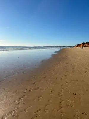 a sandy beach with footprints in the sand at Falesia Beach Town house 2 bedroom in Olhos de Água