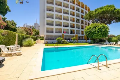 a swimming pool in front of a building at Cosy studio apartment in Vilamoura in Quarteira