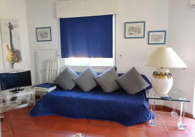 a bedroom with a blue bed with pillows and a window at Cosy studio apartment in Vilamoura in Quarteira