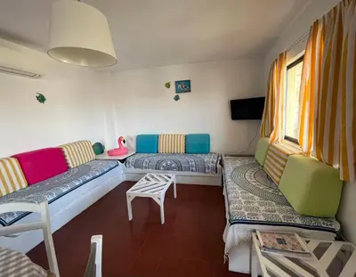 a living room with a couch and a table and chairs at Olhos do mar 209 grande terraço vista mar in Olhos de Água