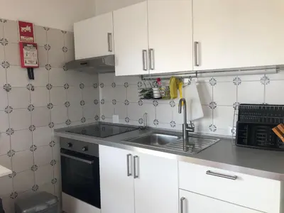 a kitchen with a microwave and a view of a balcony at Olhos do mar 209 grande terraço vista mar in Olhos de Água