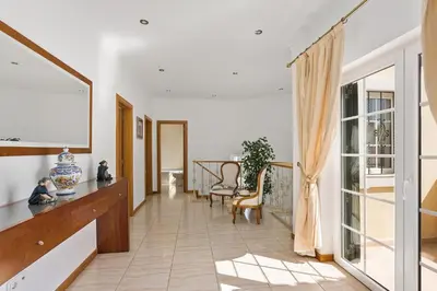 a hallway with white walls and a large window at Villa Carvalho by Villa Plus in Albufeira
