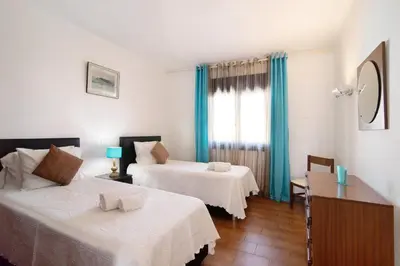 a bedroom with a bed and a desk and a window at T2 Balaia in Albufeira
