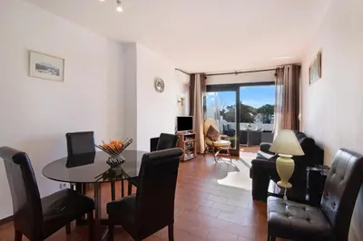 a living room with a table and chairs at T2 Balaia in Albufeira