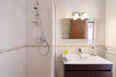 a white bathroom with a sink and a shower at T2 Balaia in Albufeira