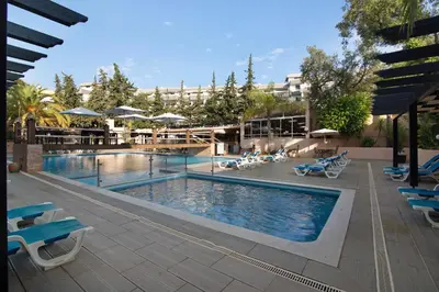 a pool at a hotel with chairs and umbrellas at T2 Balaia in Albufeira