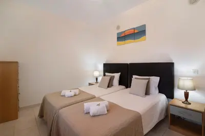 a bedroom with two beds and a mirror at T2 Bosque de São José in Albufeira