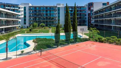 an outdoor tennis court with trees and buildings at RESIDENCE GOLF CLUB by Intiholidays in Vilamoura