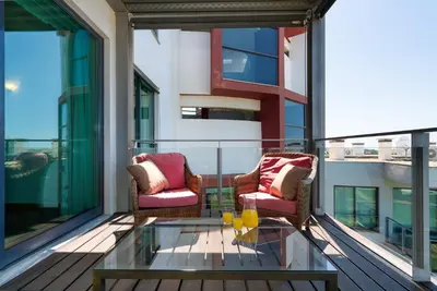a balcony with two chairs and a glass coffee table at RESIDENCE GOLF CLUB by Intiholidays in Vilamoura