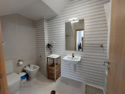 a bathroom with a sink and a toilet and a mirror at Encosta do Sol Apartamentos in Albufeira