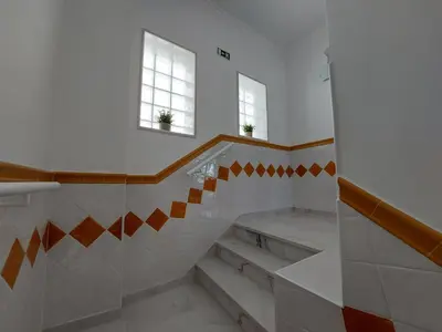 a bathroom with stairs and two windows in a building at Encosta do Sol Apartamentos in Albufeira