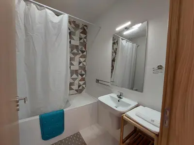 a white bathroom with a sink and a shower at Encosta do Sol Apartamentos in Albufeira