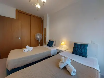 two beds sitting next to each other in a room at Encosta do Sol Apartamentos in Albufeira