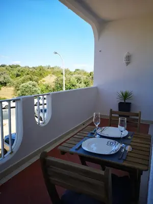 a table with two wine glasses on a balcony at Apartamento Recanto do Avô in Albufeira