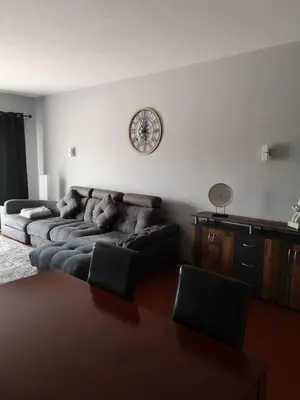 a living room with two couches and a clock on the wall at Apartamento Recanto do Avô in Albufeira