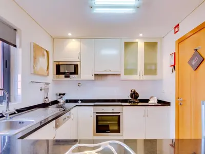 a kitchen with white cabinets and a sink at AL - Victoria Gardens in Vilamoura