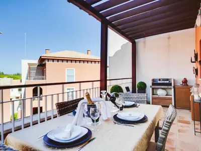 a table on a balcony with a view of a building at AL - Victoria Gardens in Vilamoura