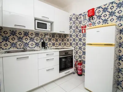 a kitchen with white appliances and blue and white tiles at Old Town Apartment by Stay ici Algarve Holiday Rental in Albufeira