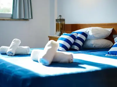 two beds with white and blue sheets and pillows at Old Town Apartment by Stay ici Algarve Holiday Rental in Albufeira