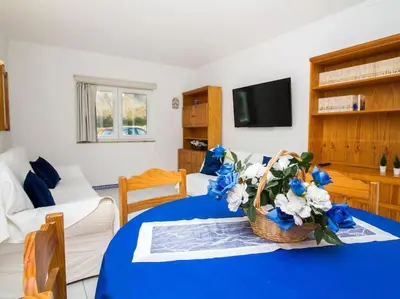 a living room with a blue table with a basket of flowers at Old Town Apartment by Stay ici Algarve Holiday Rental in Albufeira