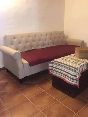 a tufted bed in a room next to a table at CASA DO POÇO in Faro