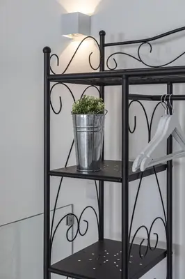 a black shelf with a potted plant on it at Casa da Praca - City Center - Faro in Faro