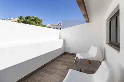 a balcony with two white chairs and a window at Casa da Praca - City Center - Faro in Faro