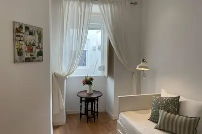 a living room with a couch and a table with a window at Janelas Verdes 37 in Faro